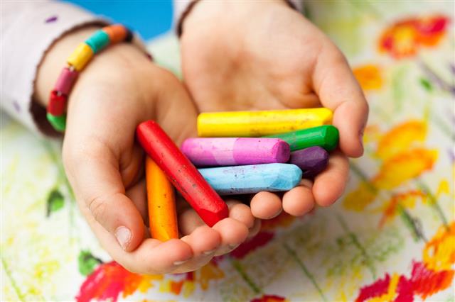 Child Holding Colorful Crayons