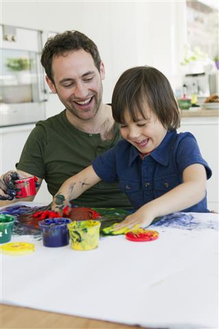 Father And Son Finger Painting Together