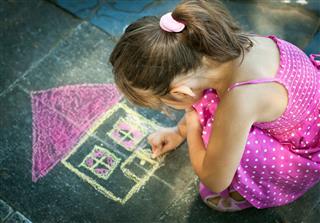 Little Girl Drawing On The Sidewalk