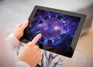 Woman reading horoscopes on tablet