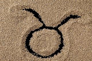 Zodiac sign taurus on sand