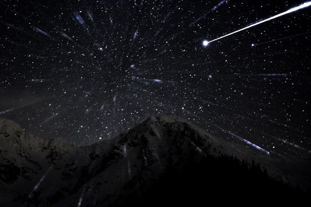 Winter mountain landscape with stars trails symbolizing space travel