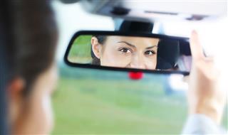 View Of Girl In Car Mirror
