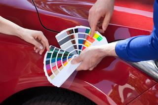 Mechanic Showing Color Samples To Customer
