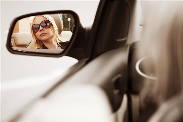 Woman Looking In Car Mirror