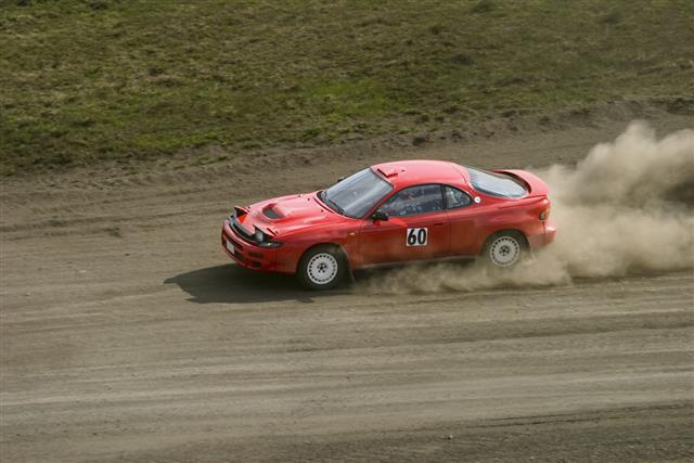 Red Car Racing Down A Dirt Road
