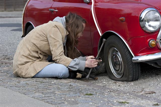 Woman Changes Tire On Her Car
