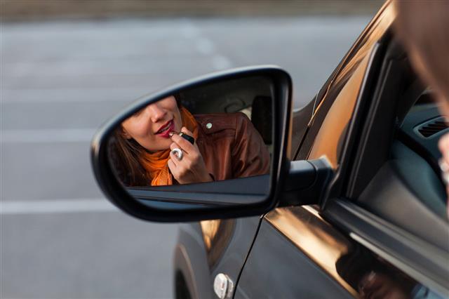 Woman Applying Lipstick In Car