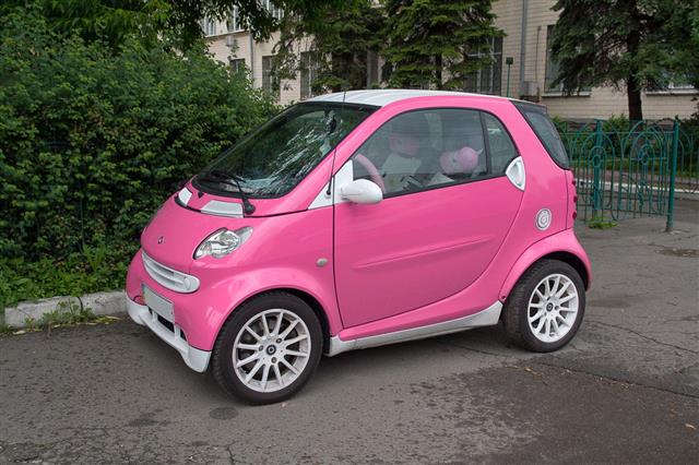 Pink Small Car Parked On Sidewalk