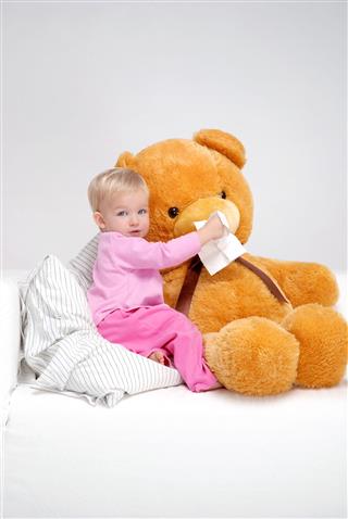 Little Girl Wiping Teddy Bears Nose