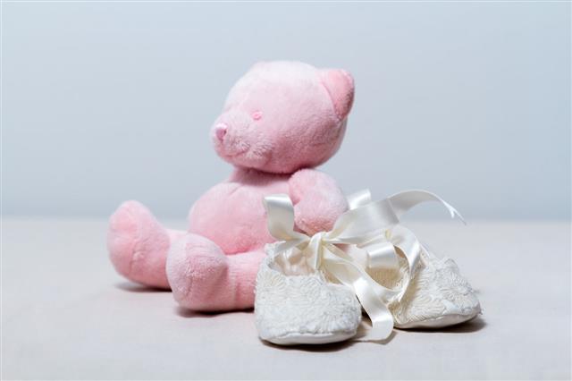 Lace Baby Booties And A Pink Teddy Bear