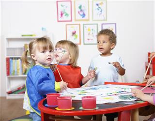 Preschooler Painting In A Nursery Setting