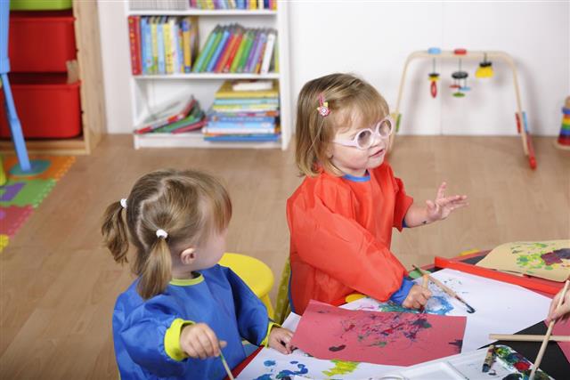 Toddlers Offering An Explanation During Art And Craft At Nursery