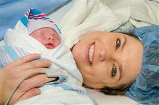 Mother hugs her new infant after delivery
