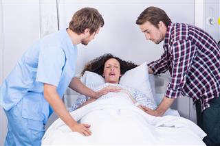 Doctor and man comforting pregnant woman