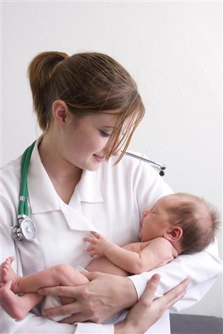 Female doctor holding a new born baby
