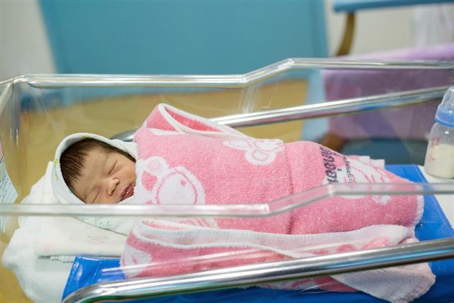 Newborn infant asleep in the blanket in delivery room
