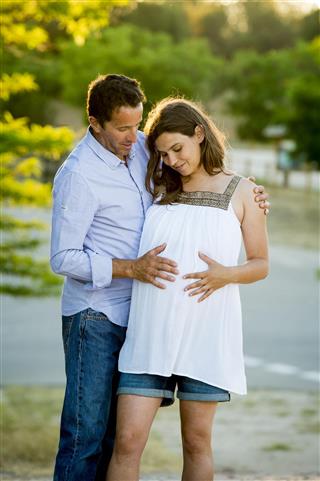 Happy couple in love together on sunset with pregnant woman