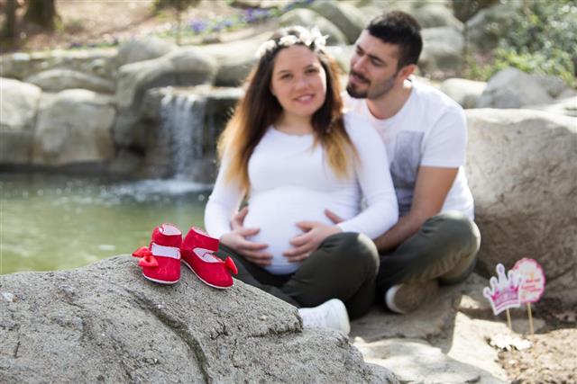 Red baby shoes and baby expectant couple