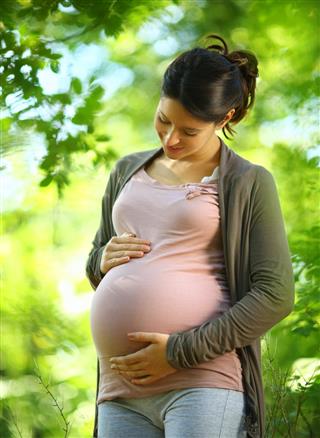 Smiling pregnant woman in a forest