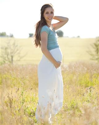 Pregnant Woman in Field and Wind Outdoors
