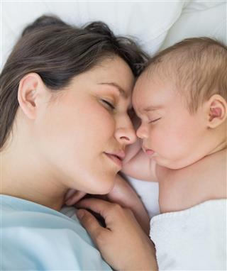 Mother and baby sleeping in a bed