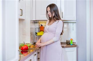 Beautiful pregnant woman cooking