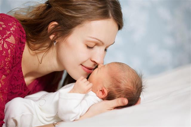 Picture of happy mother with baby in bedroom
