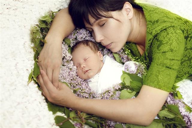 Young mother sleeps with a newborn child