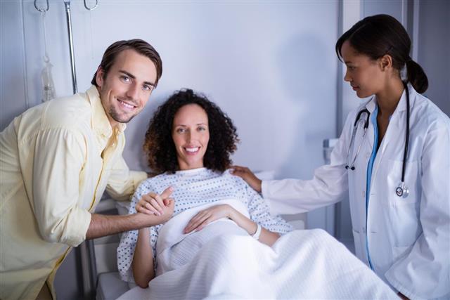 Doctor and man comforting pregnant woman