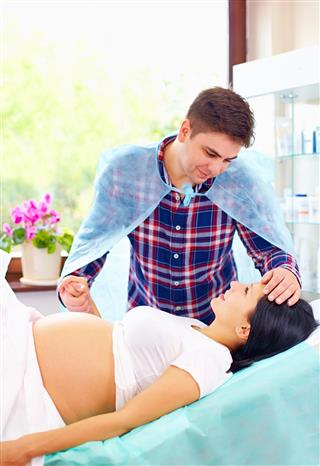 Partner soothing pregnant woman during affiliate childbirth