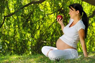 Pregnant woman with an apple