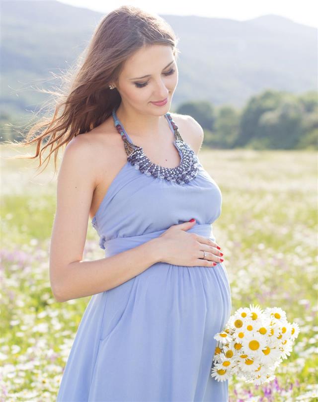 Pregnant woman with bouquet of daisy flowers