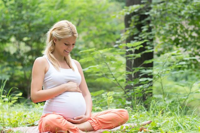 Pregnant woman's sitting in a position lotus