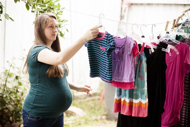 Attractive Pregnant Woman Hanging Laundry