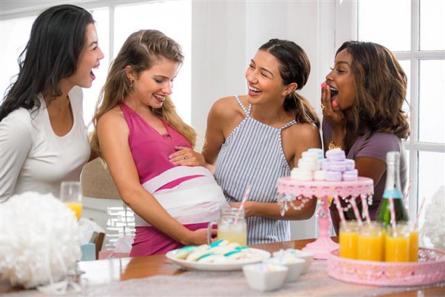 Group diverse friends women baby-shower fun playing game laughing smiling