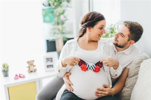 Pregnant woman with husband in living room