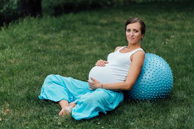Pregnant yoga prenatal doing different exercises with fitness ball