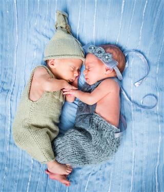 Newborn twins sleeping on a basket