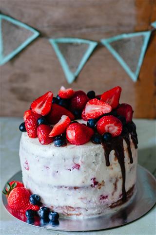Rustic cake with berries and strawberries on the table