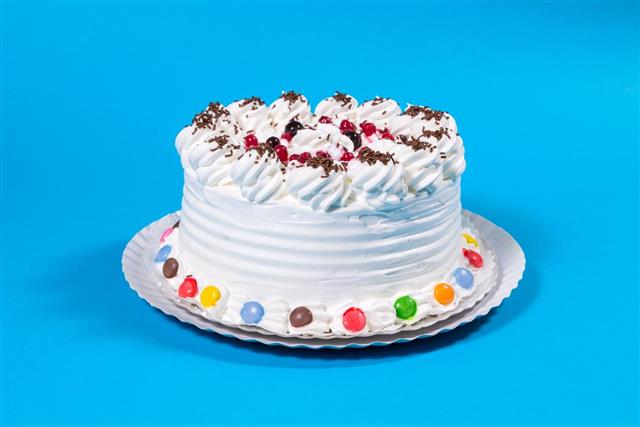 Tasty creamy birthday cake colorful candy adorned