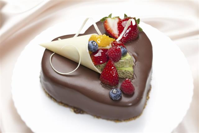 Chocolate cake in from of a heart with various berries