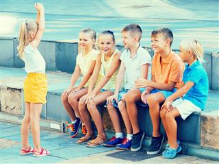 Cheerful kids playing charades outdoors