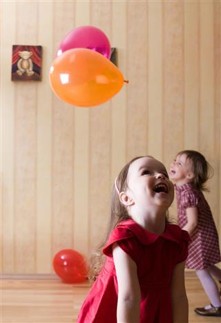 Portrait of two little girls playing with airy balls
