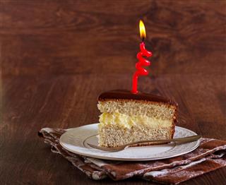 Cake with candles on dark wooden background