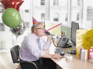 Businessman having birthday party at desk