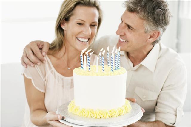 Smiling Man and Woman Holding a Birthday Cake