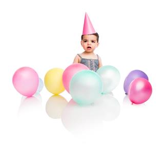 Upset baby girl with party decoration