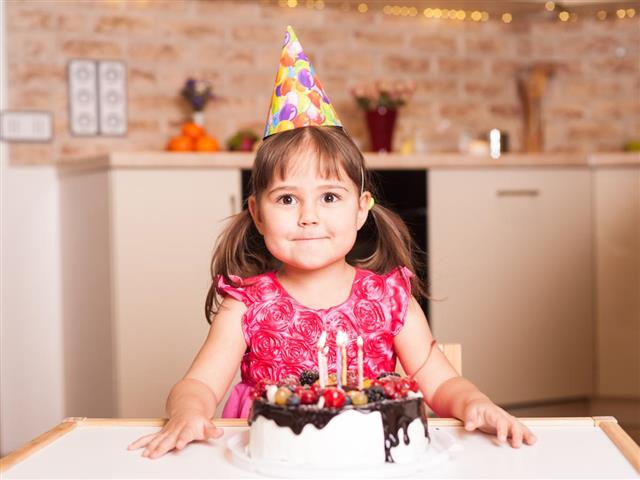 Happy kid girl with cake celebrating happy birthday