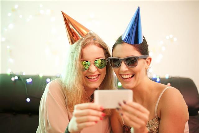 Two Young Female Friends Taking Selfie during Christmas Party